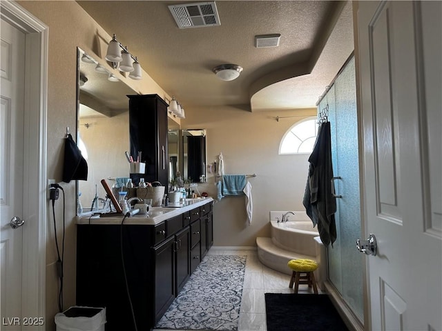 6454 Mount Palomar Ave, Las Vegas, NV 89139 - bathroom featuring a bath, double vanity, a textured ceiling, a shower stall, and tile patterned flooring
