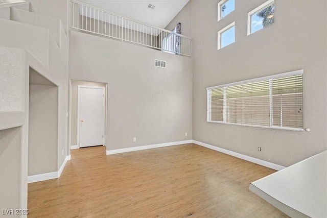 927 Clear Diamond Ave, Las Vegas, NV 89123 - unfurnished living room featuring a high ceiling, wood finished floors, and baseboards
