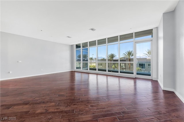 4575 Dean Martin Dr Unit 304, Las Vegas, NV 89103 - unfurnished room with plenty of natural light, a wall of windows, dark wood-style flooring, and baseboards