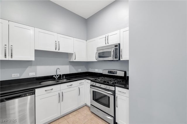 4575 Dean Martin Dr Unit 304, Las Vegas, NV 89103 - kitchen with stainless steel appliances, a sink, white cabinetry, and dark countertops