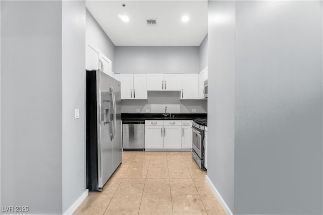 4575 Dean Martin Dr Unit 304, Las Vegas, NV 89103 - kitchen with stainless steel appliances, a sink, white cabinets, dark countertops, and recessed lighting