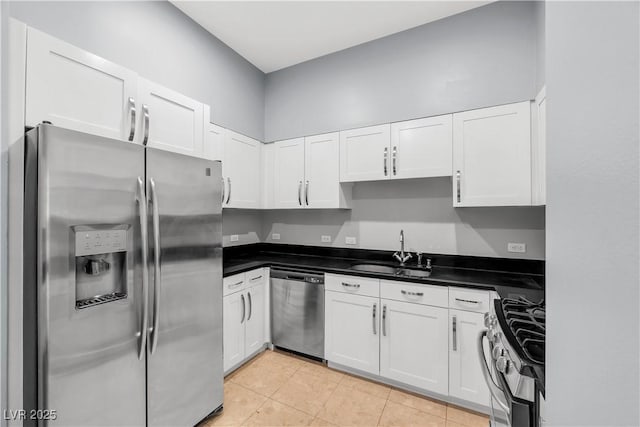 4575 Dean Martin Dr Unit 304, Las Vegas, NV 89103 - kitchen with stainless steel appliances, a sink, white cabinets, dark countertops, and light tile patterned flooring
