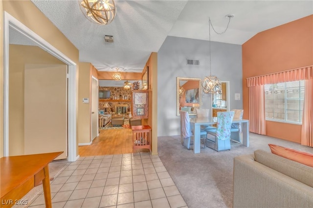 6508 Peppermill Dr, Las Vegas, NV 89146 - living area featuring a chandelier, light tile patterned flooring, high vaulted ceiling, and light carpet