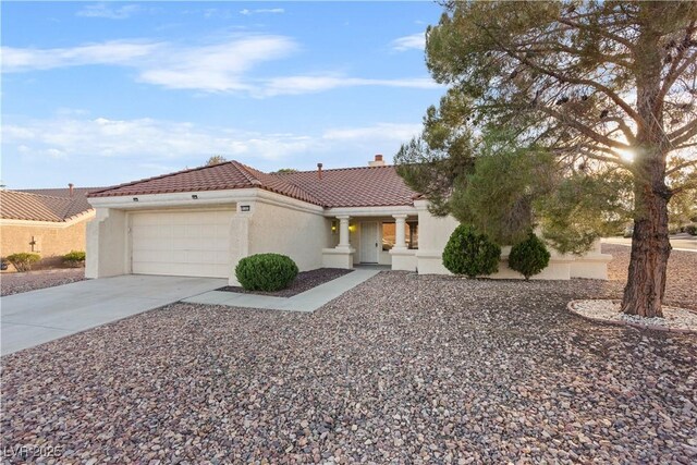 9105 Marble Dr, Las Vegas, NV 89134 - mediterranean / spanish house featuring concrete driveway, a garage, stucco siding, a tile roof, and a chimney