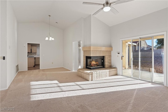 9105 Marble Dr, Las Vegas, NV 89134 - unfurnished living room featuring high vaulted ceiling, light carpet, a brick fireplace, ceiling fan, and a chandelier