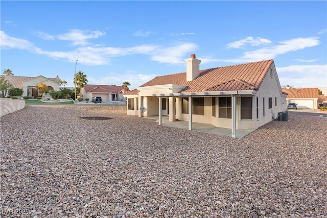 9105 Marble Dr, Las Vegas, NV 89134 - back of house with a tile roof, a patio area, stucco siding, a chimney, and central air condition unit