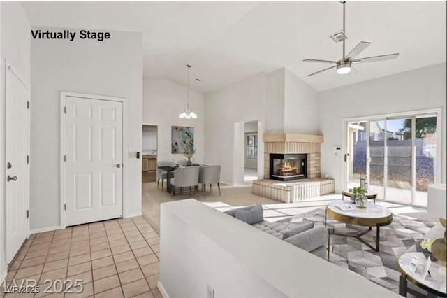 9105 Marble Dr, Las Vegas, NV 89134 - living room with high vaulted ceiling, a ceiling fan, a brick fireplace, light tile patterned flooring, and a chandelier