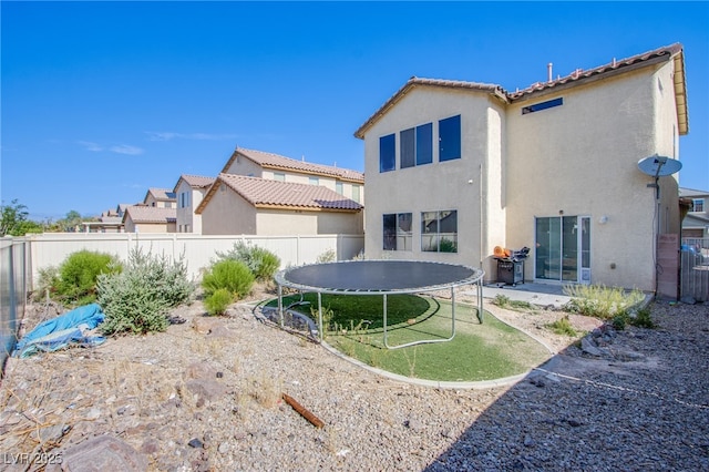 4429 E Azure Ave, Las Vegas, NV 89115 - back of house with a trampoline, a fenced backyard, and stucco siding