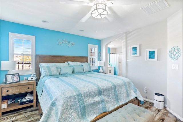 2225 Chandler Ranch Pl, Laughlin, NV 89029 - bedroom featuring wood finished floors, arched walkways, baseboards, and a ceiling fan