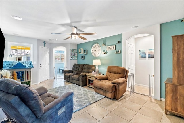2225 Chandler Ranch Pl, Laughlin, NV 89029 - living room with arched walkways, light tile patterned flooring, ceiling fan, and baseboards