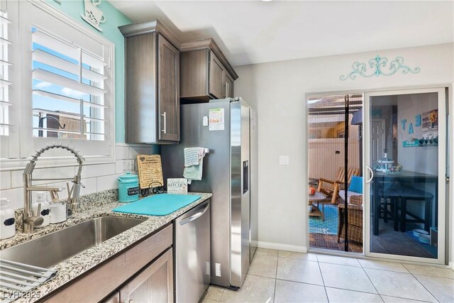 2225 Chandler Ranch Pl, Laughlin, NV 89029 - kitchen featuring dishwasher, a sink, light stone countertops, light tile patterned flooring, and tasteful backsplash