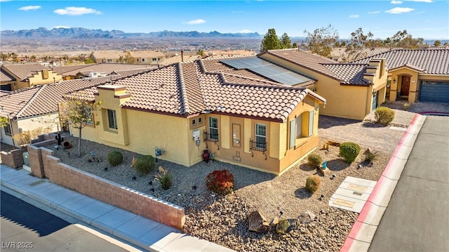 2225 Chandler Ranch Pl, Laughlin, NV 89029 - view of front facade featuring a tile roof, stucco siding, solar panels, a mountain view, and a residential view