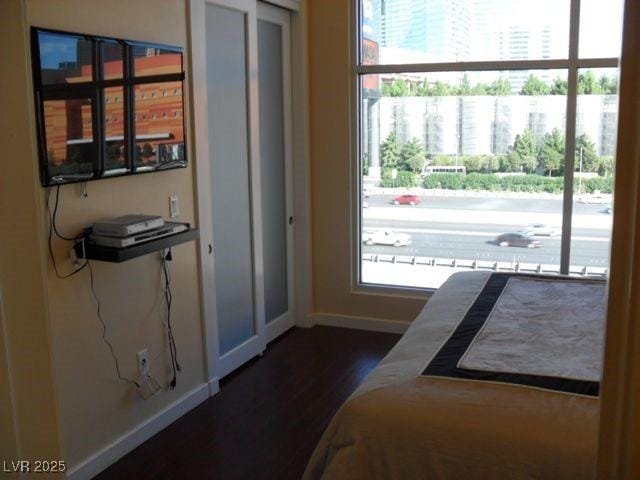 4585 Dean Martin Dr Unit 205, Las Vegas, NV 89103 - bedroom featuring baseboards and dark wood finished floors
