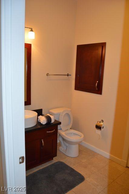 4585 Dean Martin Dr Unit 205, Las Vegas, NV 89103 - half bath featuring vanity, baseboards, toilet, and tile patterned floors