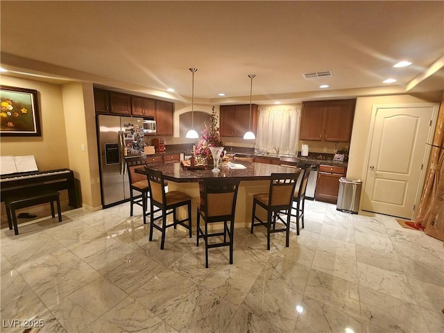 6729 Flamenco Ct, Las Vegas, NV 89139 - kitchen with stainless steel appliances, dark countertops, a breakfast bar area, recessed lighting, and a kitchen island