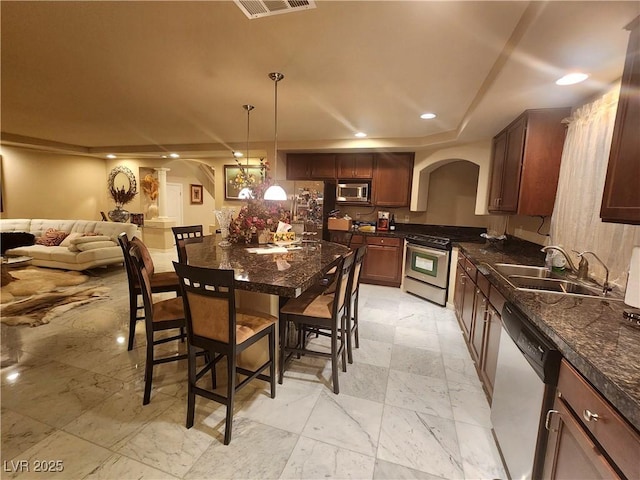 6729 Flamenco Ct, Las Vegas, NV 89139 - kitchen with appliances with stainless steel finishes, a sink, arched walkways, dark countertops, and recessed lighting