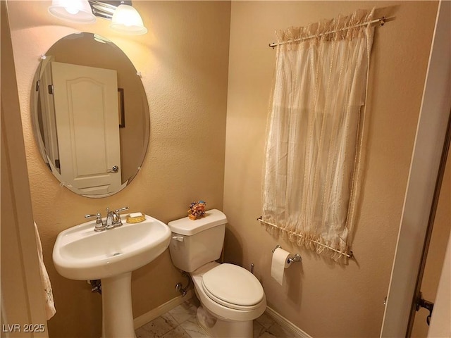 6729 Flamenco Ct, Las Vegas, NV 89139 - half bath featuring toilet, marble look tile flooring, and baseboards