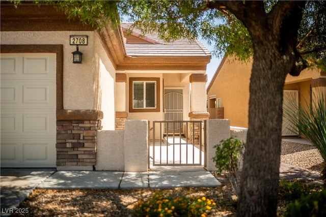 2708 Cheer Pheasant Ave, North Las Vegas, NV 89084 - doorway to property with stucco siding, a gate, stone siding, and a garage