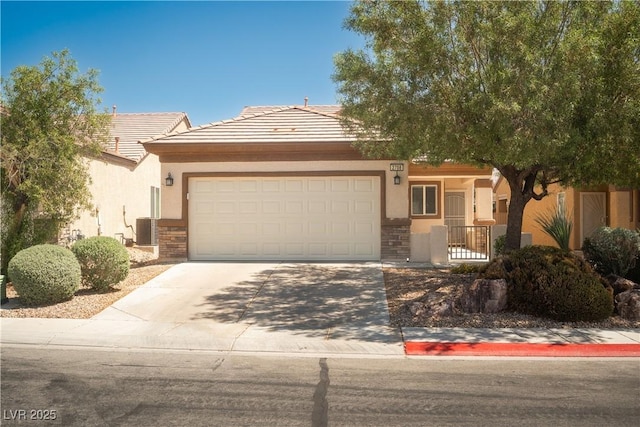 2708 Cheer Pheasant Ave, North Las Vegas, NV 89084 - view of front of property featuring stucco siding, stone siding, an attached garage, and driveway