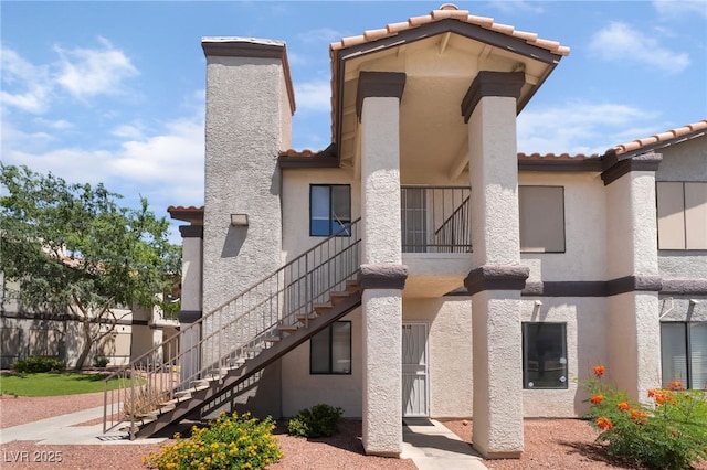 1575 W Warm Springs Rd Unit 2822, Henderson, NV 89014 - rear view of property with a tile roof, stairway, stucco siding, and a chimney