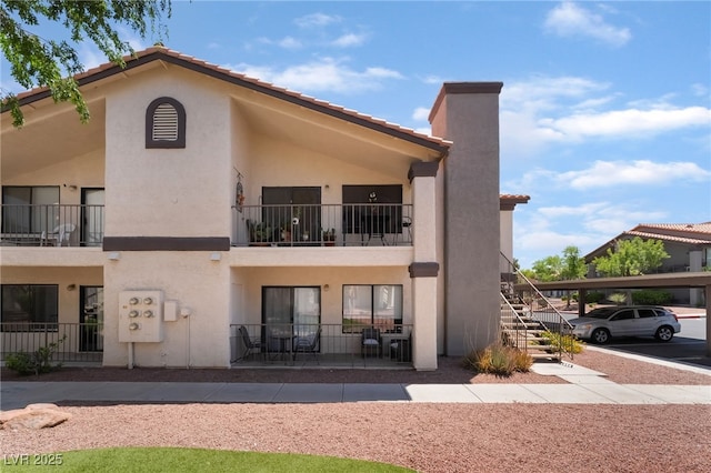 1575 W Warm Springs Rd Unit 2822, Henderson, NV 89014 - back of property featuring stucco siding, stairs, covered parking, and a tile roof
