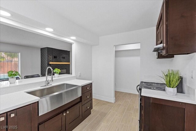 2408 Berkley Ave, Las Vegas, NV 89101 - kitchen featuring a sink, light countertops, dark brown cabinets, baseboards, and recessed lighting