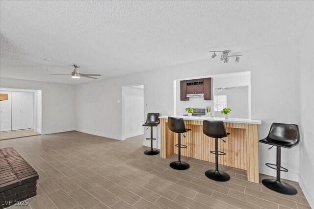 2408 Berkley Ave, Las Vegas, NV 89101 - kitchen featuring a kitchen breakfast bar, light countertops, a ceiling fan, a textured ceiling, and a peninsula
