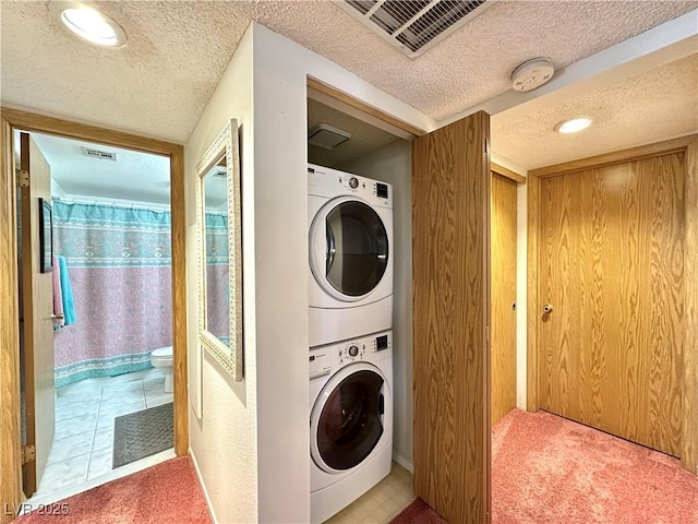 4151 Sanderling Cir Unit 351, Las Vegas, NV 89103 - laundry area with estacked washer and dryer, a textured ceiling, carpet floors, and baseboards