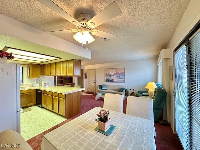 4151 Sanderling Cir Unit 351, Las Vegas, NV 89103 - kitchen with brown cabinetry, a textured ceiling, open floor plan, tile counters, and a peninsula