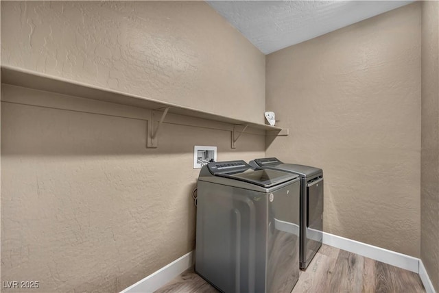 7029 Bocaire Dr, Las Vegas, NV 89131 - laundry area featuring washing machine and clothes dryer, baseboards, wood finished floors, and a textured wall