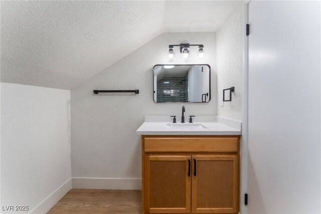 3409 El Cortez Ave, Las Vegas, NV 89102 - bathroom with vaulted ceiling, vanity, a textured ceiling, wood finished floors, and baseboards