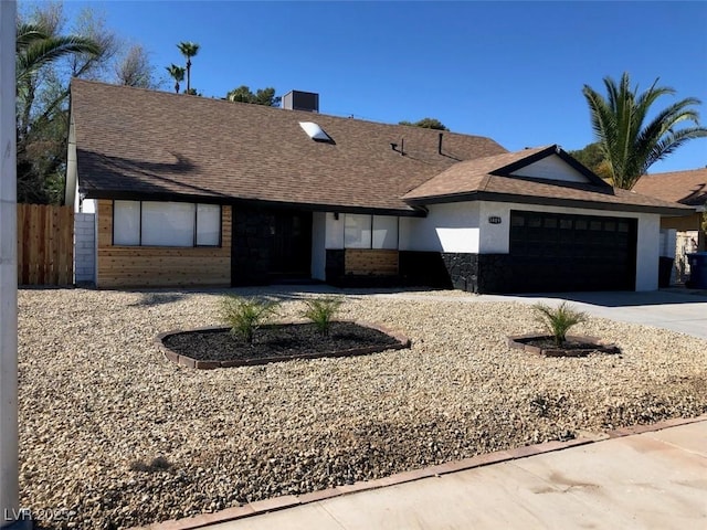 3409 El Cortez Ave, Las Vegas, NV 89102 - view of front of property featuring a garage, driveway, stucco siding, a shingled roof, and stone siding