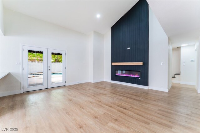 3409 El Cortez Ave, Las Vegas, NV 89102 - unfurnished living room with light wood finished floors, baseboards, and high vaulted ceiling