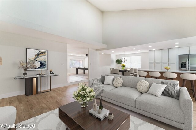 3409 El Cortez Ave, Las Vegas, NV 89102 - living room featuring light wood-type flooring, baseboards, and a towering ceiling