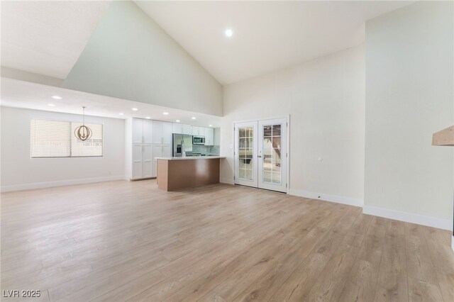3409 El Cortez Ave, Las Vegas, NV 89102 - unfurnished living room featuring high vaulted ceiling, light wood-type flooring, french doors, baseboards, and a chandelier