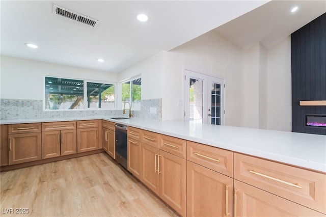 3409 El Cortez Ave, Las Vegas, NV 89102 - kitchen featuring stainless steel dishwasher, a sink, light wood finished floors, french doors, and light countertops