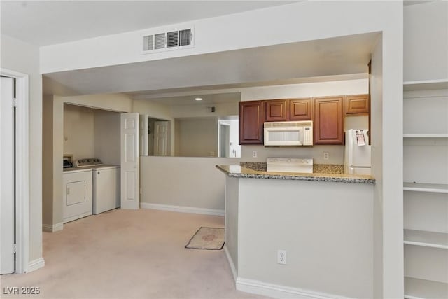5166 S Jones Blvd Unit 205, Las Vegas, NV 89118 - kitchen featuring white appliances, independent washer and dryer, light colored carpet, baseboards, and light stone countertops