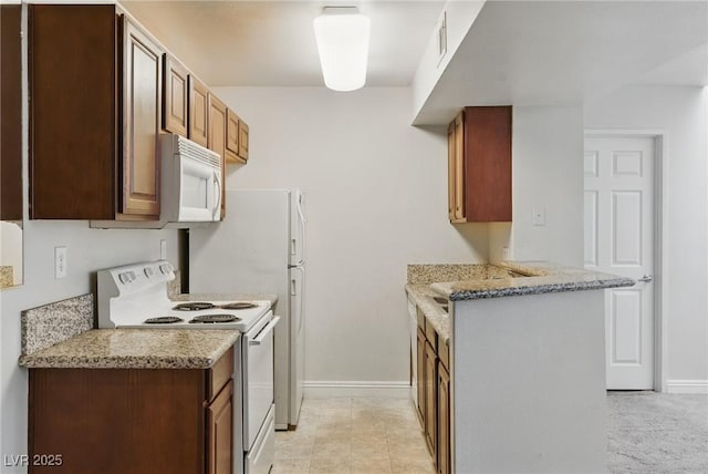 5166 S Jones Blvd Unit 205, Las Vegas, NV 89118 - kitchen with white appliances, baseboards, and light stone countertops