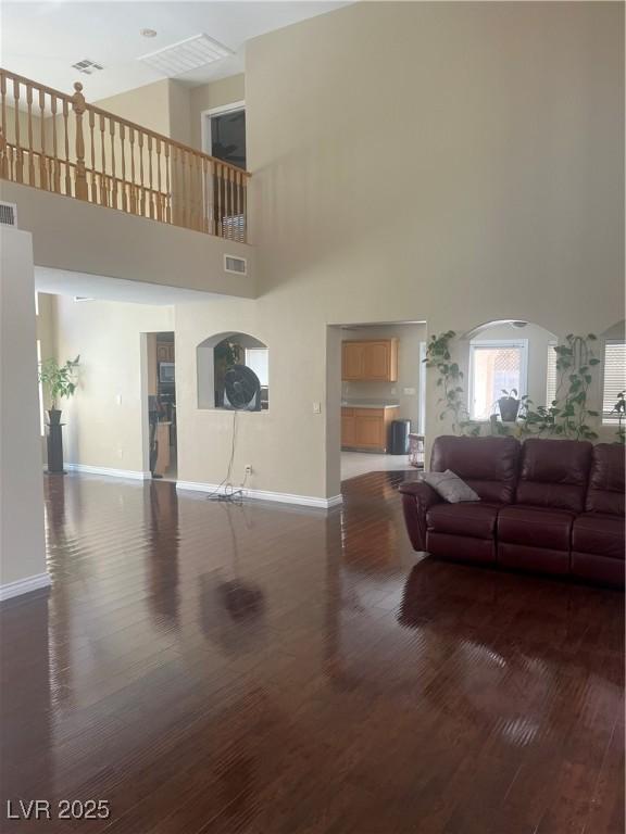 9365 Sparkling Waters Ave, Las Vegas, NV 89129 - living area featuring wood finished floors, baseboards, a high ceiling, and arched walkways