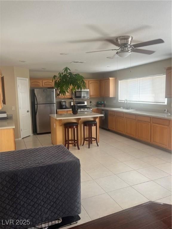 9365 Sparkling Waters Ave, Las Vegas, NV 89129 - kitchen featuring stainless steel appliances, a sink, a center island, a breakfast bar, and light countertops