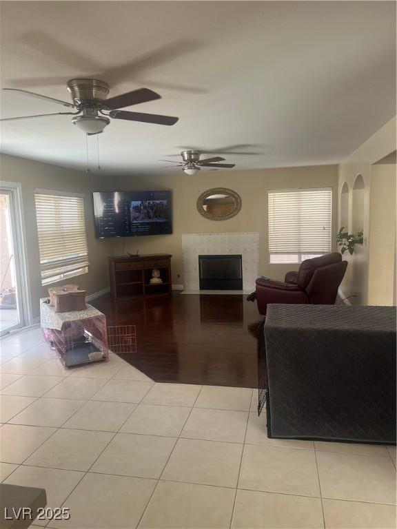 9365 Sparkling Waters Ave, Las Vegas, NV 89129 - tiled living room featuring plenty of natural light, a fireplace, and ceiling fan