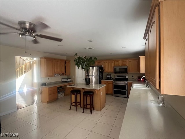 9365 Sparkling Waters Ave, Las Vegas, NV 89129 - kitchen with appliances with stainless steel finishes, a sink, a kitchen bar, a kitchen island, and a ceiling fan