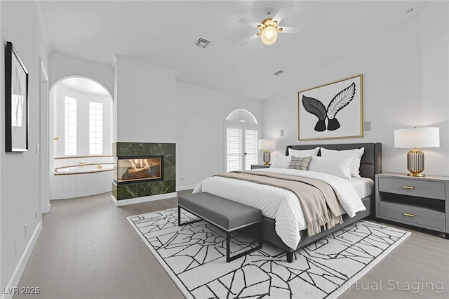 4418 Desert Bloom Ct, Las Vegas, NV 89129 - bedroom featuring a tile fireplace, multiple windows, wood finished floors, lofted ceiling, and baseboards