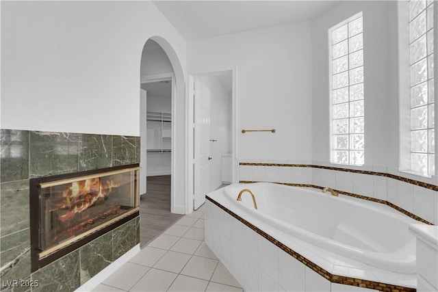 4418 Desert Bloom Ct, Las Vegas, NV 89129 - bathroom with a bath, a tiled fireplace, a spacious closet, and tile patterned floors