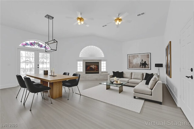 4418 Desert Bloom Ct, Las Vegas, NV 89129 - living room featuring light wood-type flooring, a ceiling fan, french doors, a tiled fireplace, and vaulted ceiling