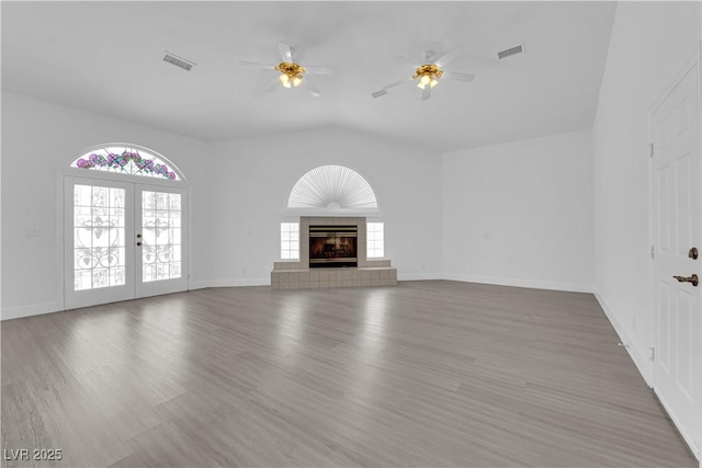 4418 Desert Bloom Ct, Las Vegas, NV 89129 - unfurnished living room featuring a ceiling fan, wood finished floors, vaulted ceiling, a tiled fireplace, and baseboards
