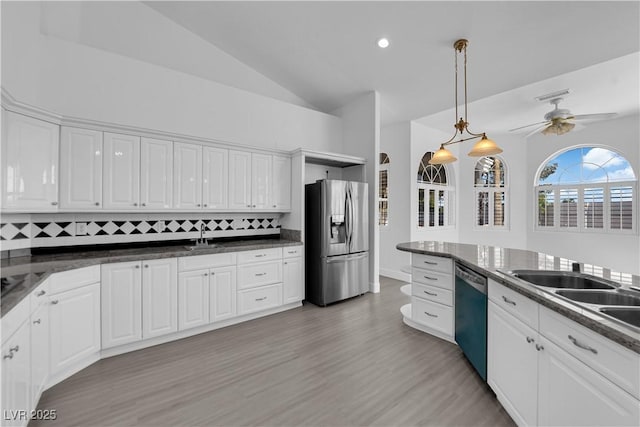 4418 Desert Bloom Ct, Las Vegas, NV 89129 - kitchen featuring stainless steel fridge, dishwasher, vaulted ceiling, white cabinets, and decorative backsplash