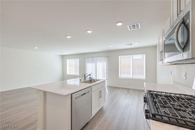 1425 Gable Falls Dr Unit 93, North Las Vegas, NV 89084 - kitchen with stainless steel appliances, a sink, light wood finished floors, white cabinetry, and recessed lighting