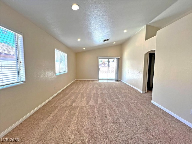 2119 Sunset Vista Ave, Henderson, NV 89052 - empty room with arched walkways, carpet floors, vaulted ceiling, healthy amount of natural light, and baseboards