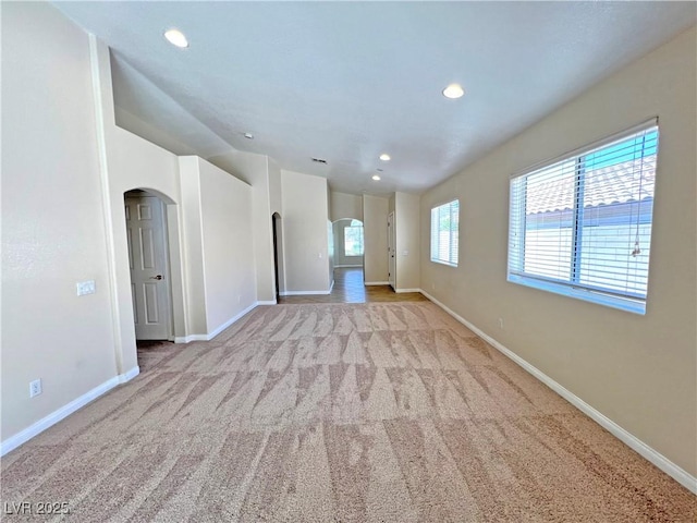 2119 Sunset Vista Ave, Henderson, NV 89052 - unfurnished living room featuring arched walkways, carpet flooring, baseboards, and recessed lighting